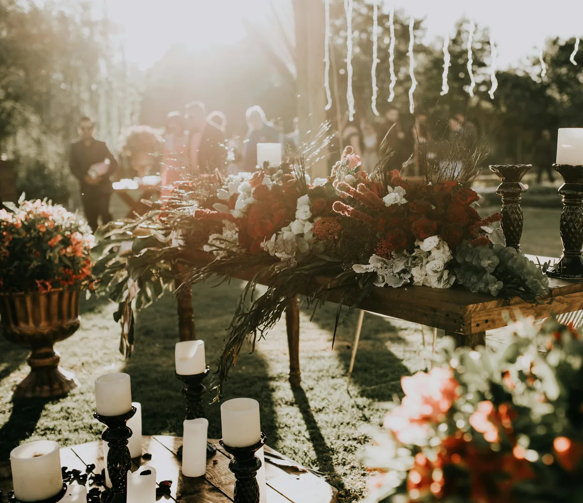 Mesa de celebração decorada com flores e velas; imagem editorial, não é produto da Mandala